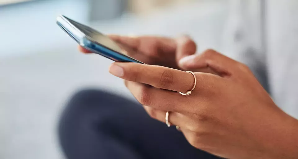 A woman’s hands holding a smartphone