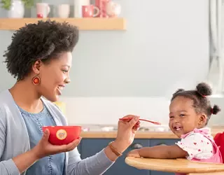 Mamá alimentando a su hija